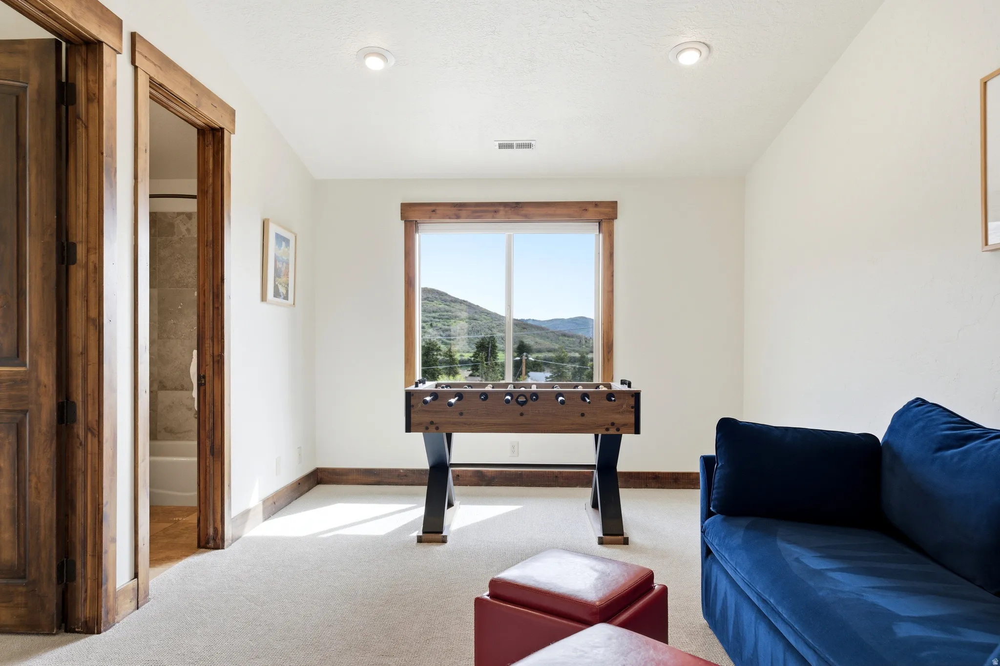 Carpeted room with a window featuring mountain scenery