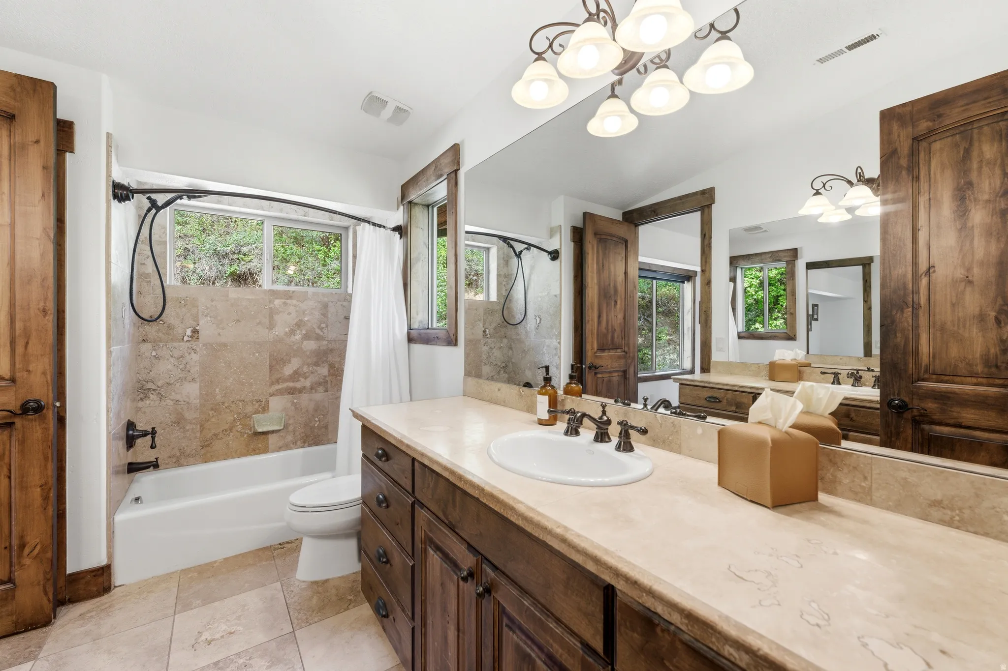 Bathroom featuring a large vanity with a single basin, extensive countertop, and wood-finish cabinetry