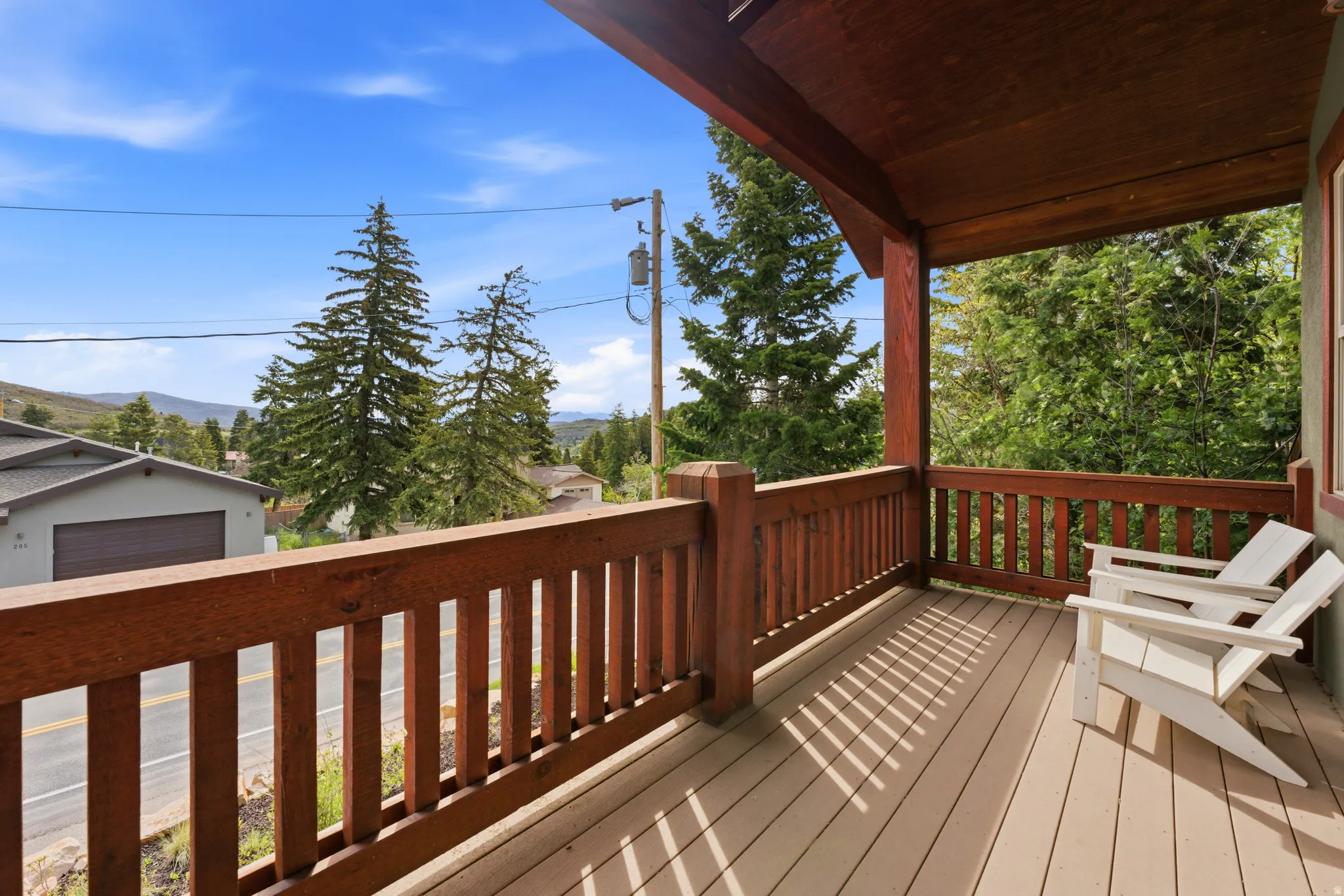 Covered wood-finish porch featuring a slatted railing and a durable composite deck