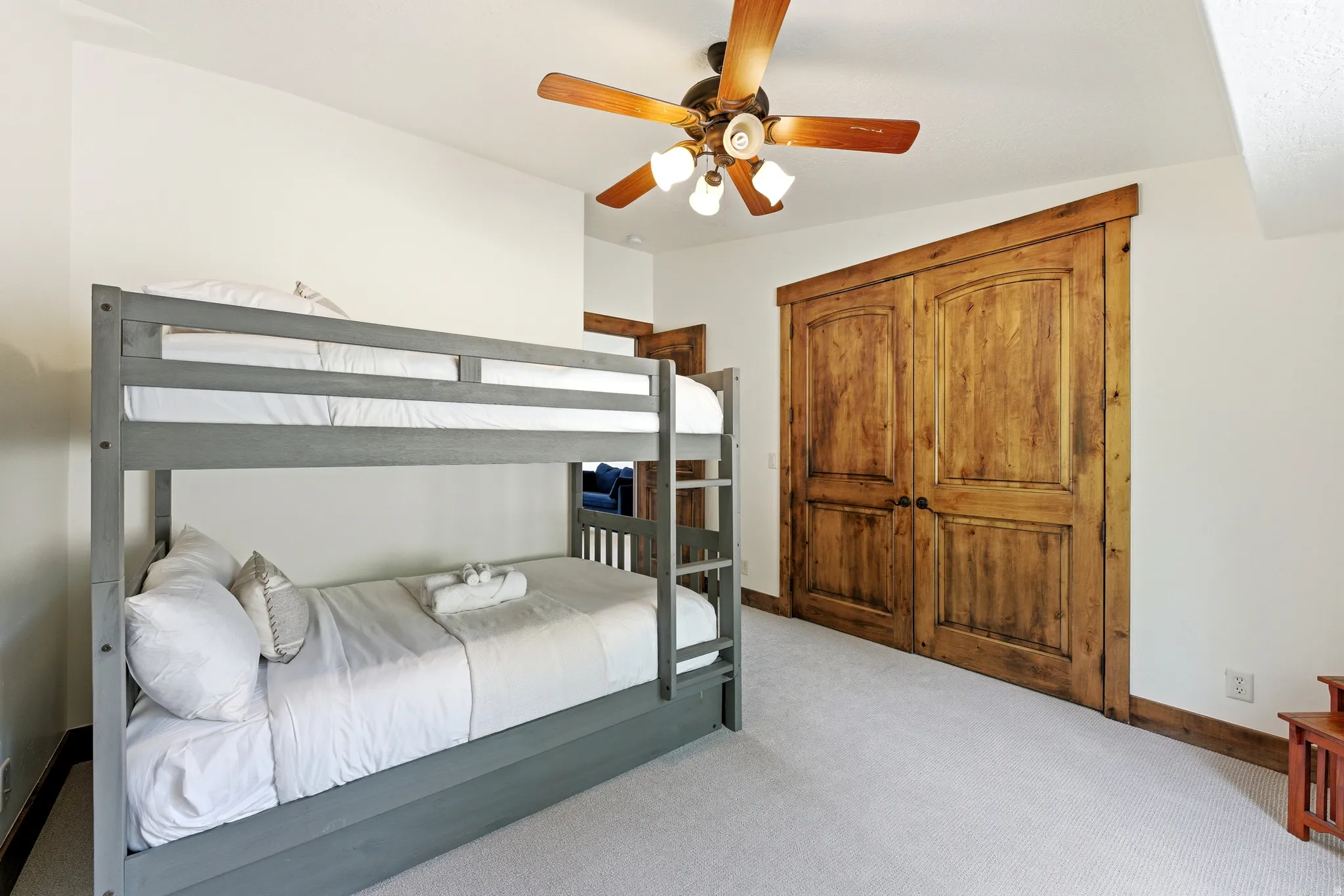 Room featuring a ceiling fan with integrated lighting, light-colored carpeting, and a built-in closet with double wooden doors