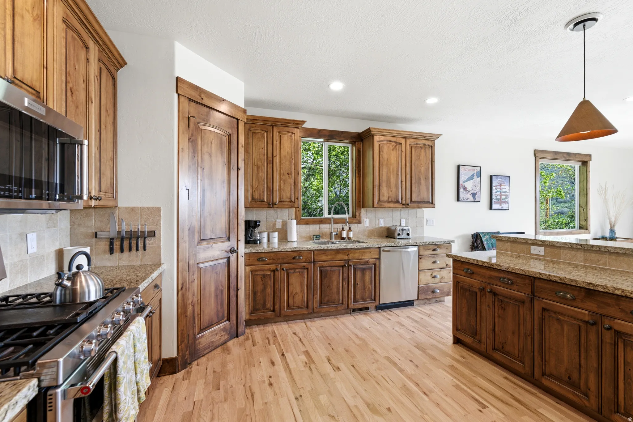 Kitchen featuring wood-finish flooring, recessed lighting, and a pendant light fixture