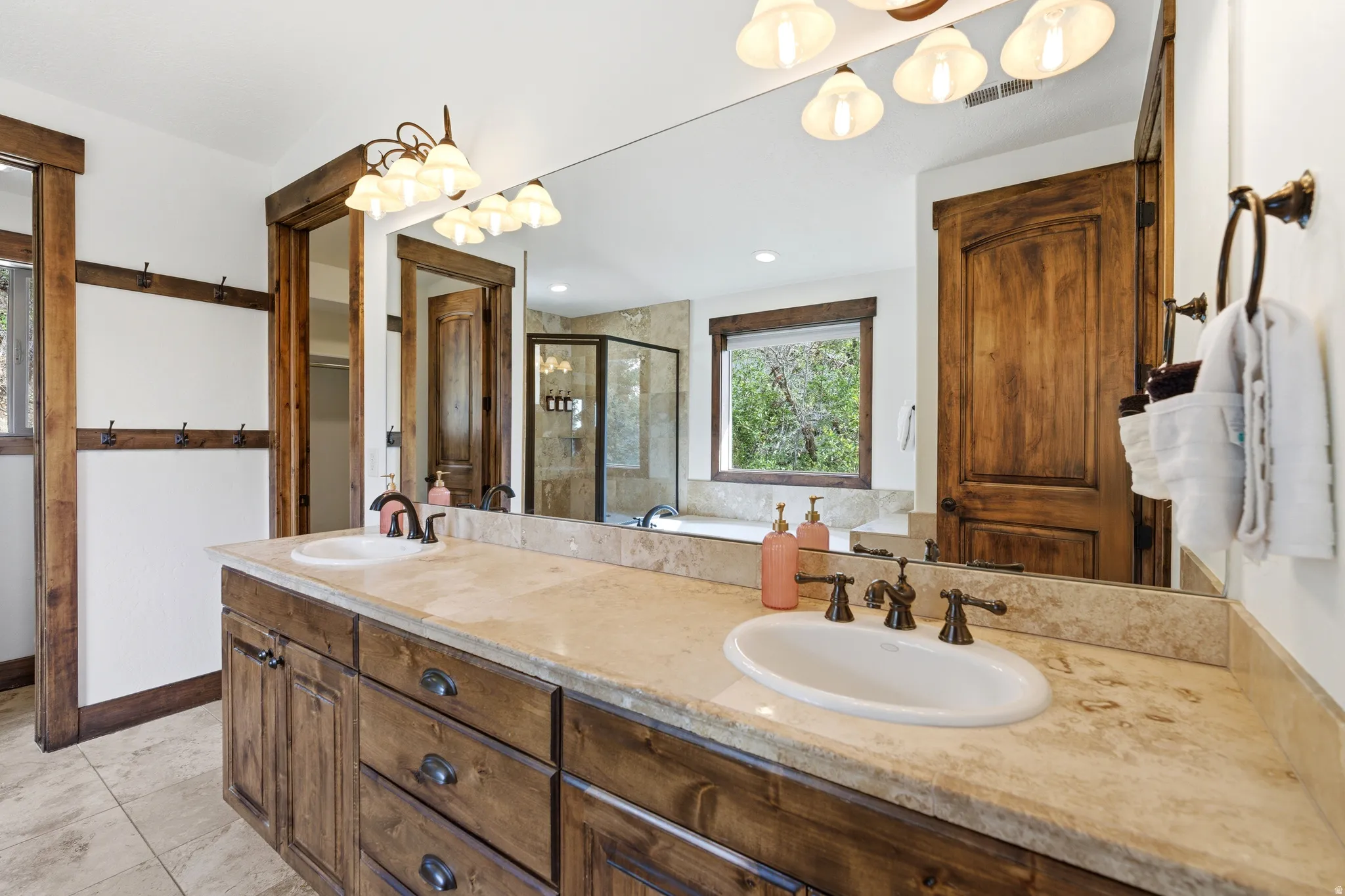 Dual vanity featuring wood-finish cabinetry and a light-toned countertop