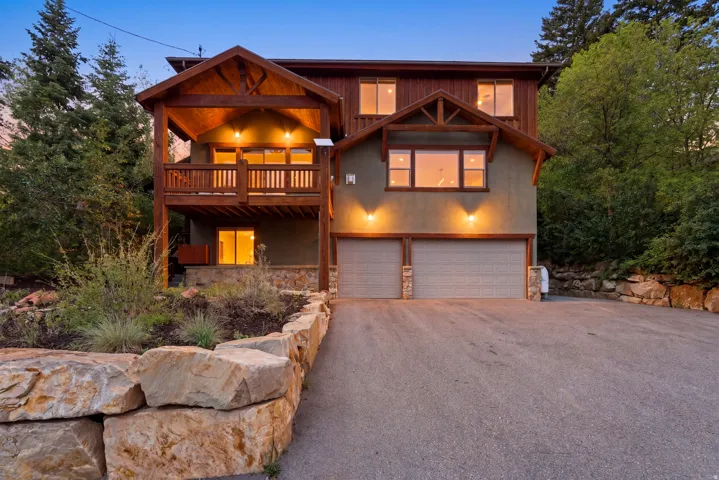 Wood-sided home with a stone facade base and a two-car garage