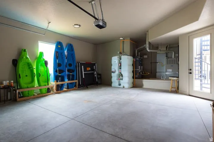 Spacious garage with concrete flooring, overhead lighting, and an automatic garage door opener