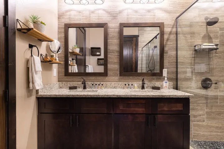 Double vanity with a granite countertop and dark wood cabinetry
