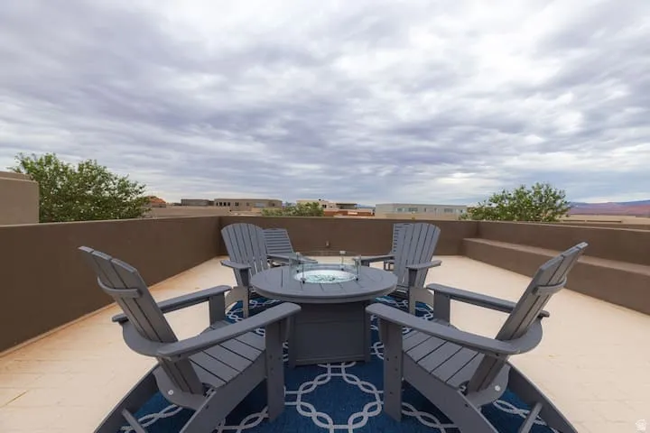 Expansive rooftop terrace featuring a low perimeter wall, integrated tiered seating, and distant mountain scenery