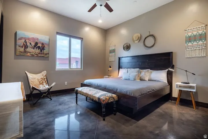 Spacious room featuring polished concrete flooring, neutral wall tones, a window with exterior views, recessed lighting, and a ceiling fan