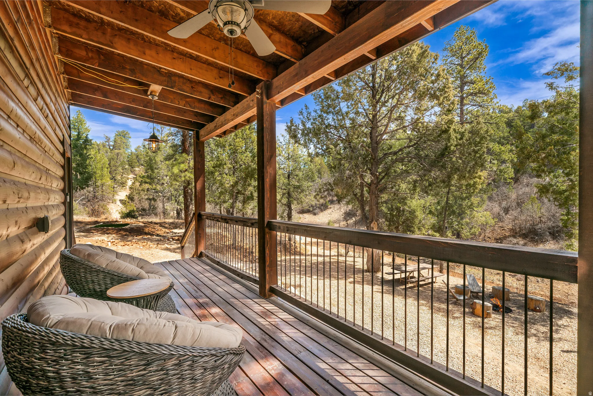 Wood-finish deck with exposed beam ceiling, ceiling fan, and metal railing