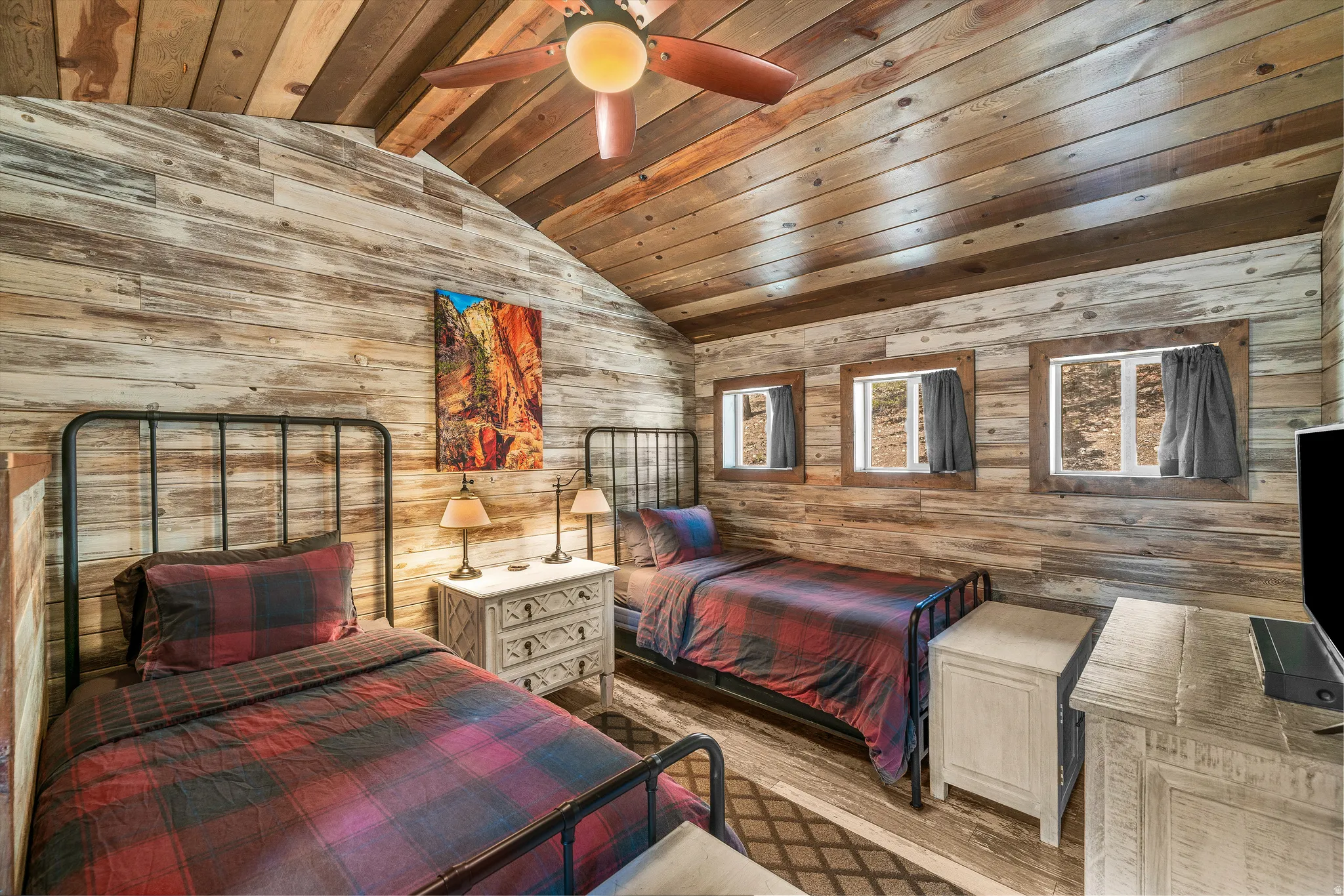 Wood-paneled room featuring a vaulted wood ceiling and three window openings