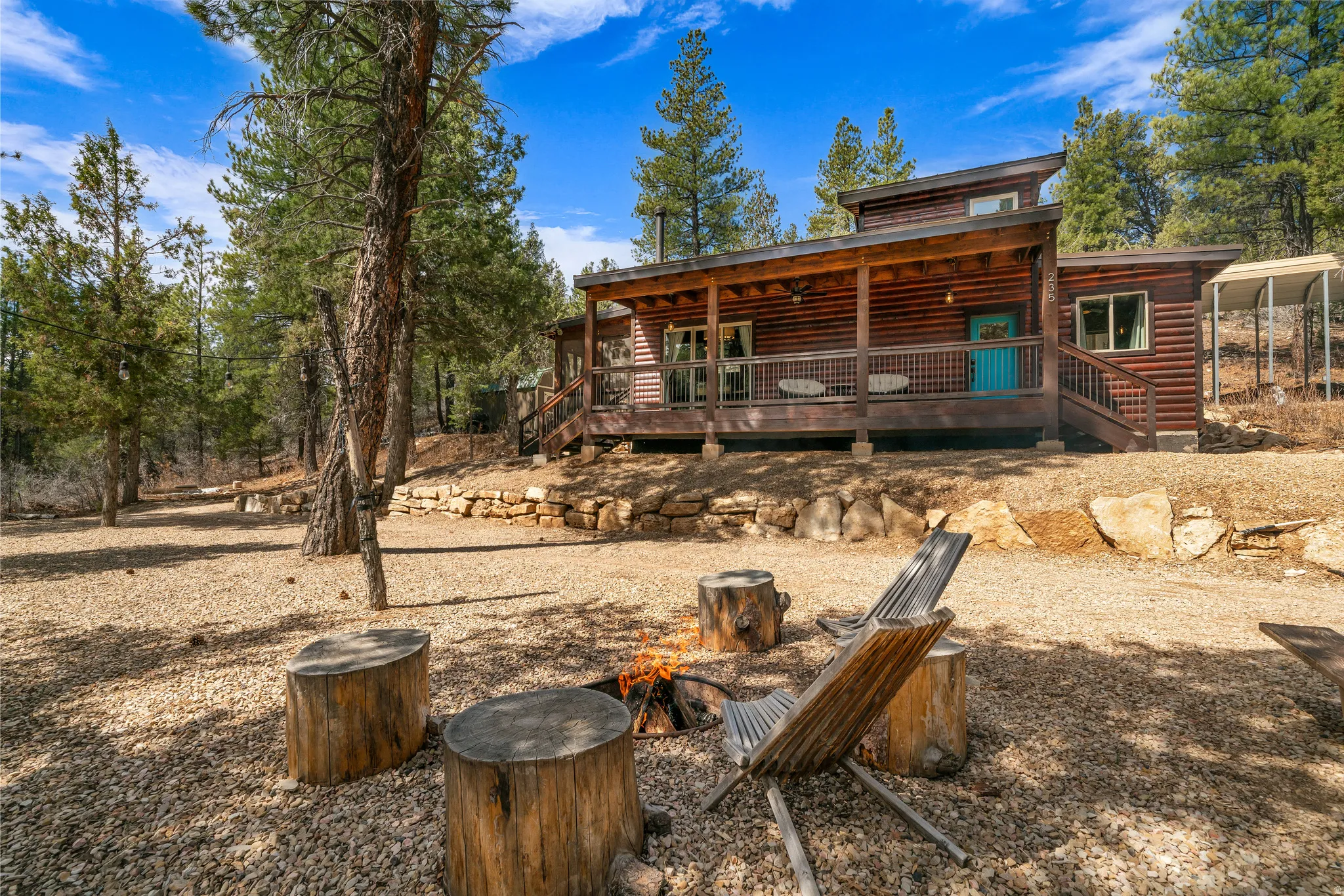 Log cabin exterior featuring a wide front porch with a turquoise entry door