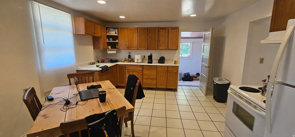 Kitchen featuring tile flooring, light wood cabinetry, white countertops, and recessed lighting