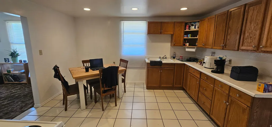 Kitchen featuring tile flooring, wood cabinetry, light-toned countertops, and recessed lighting