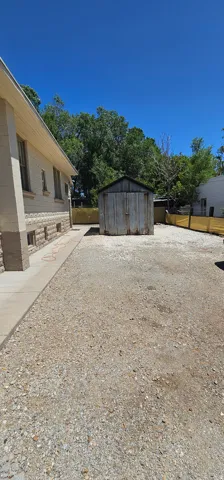 Expansive gravel area with a detached storage shed