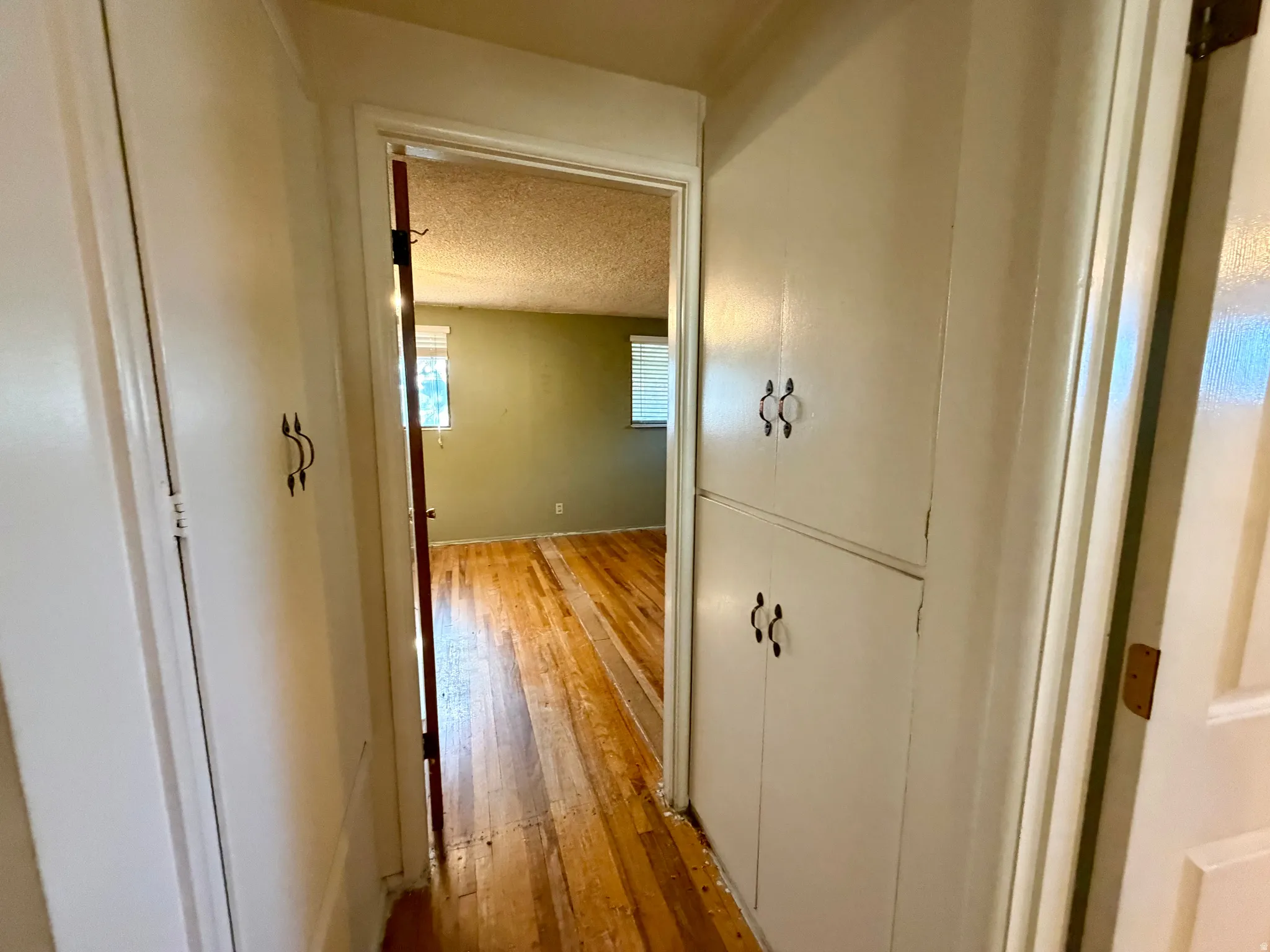 Hallway featuring built-in cabinetry with decorative hardware