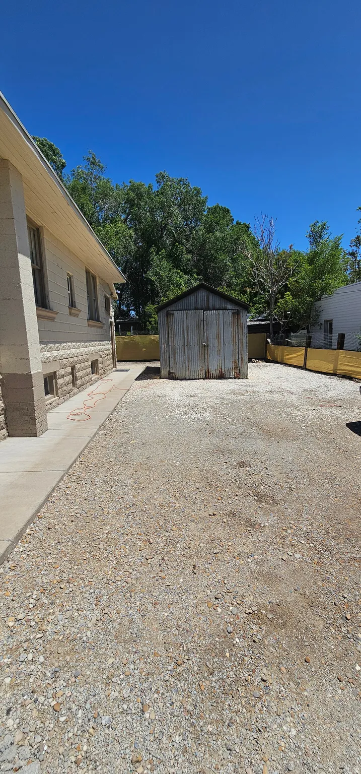 Expansive gravel area with a detached storage shed