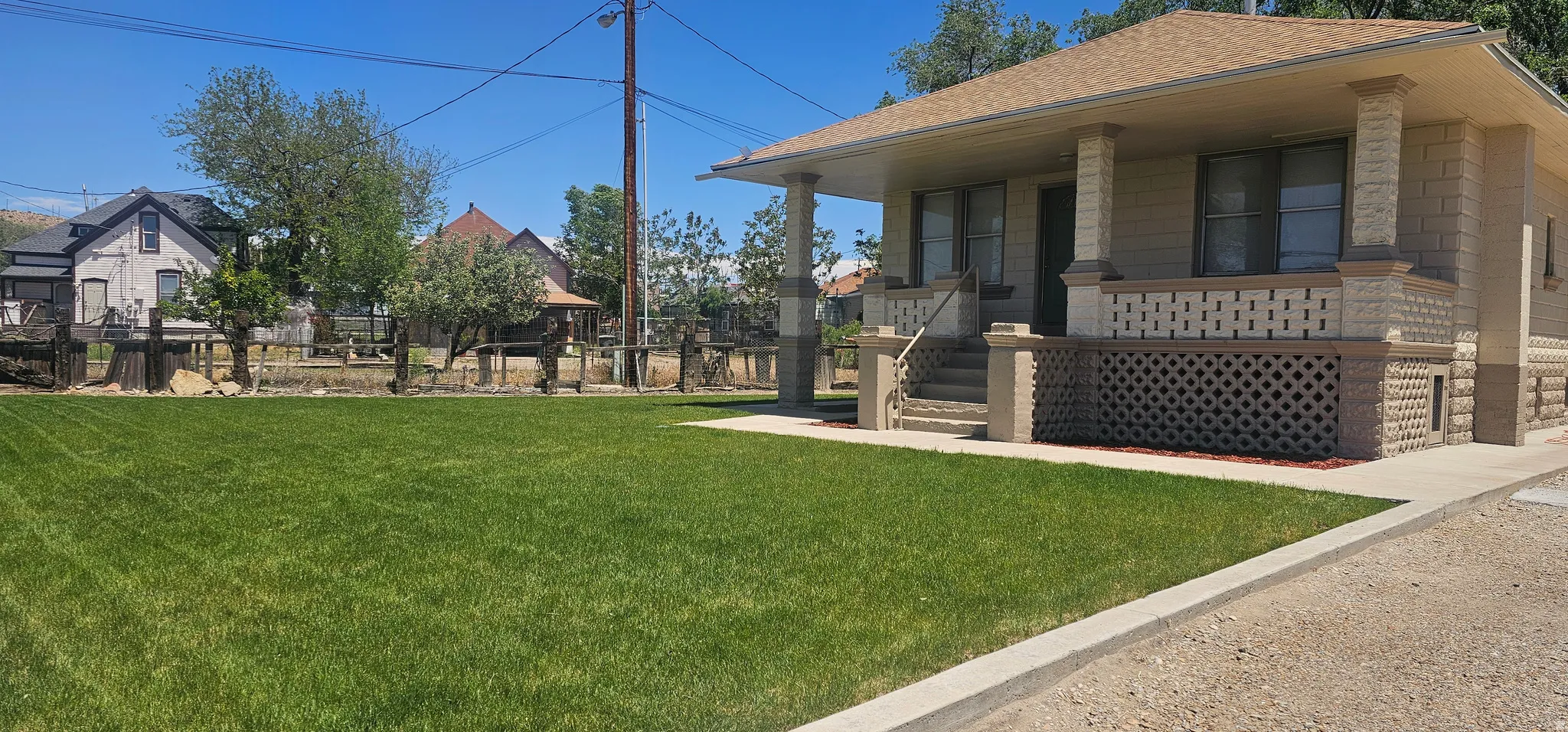 House exterior featuring a front porch with decorative lattice, stone columns, and steps