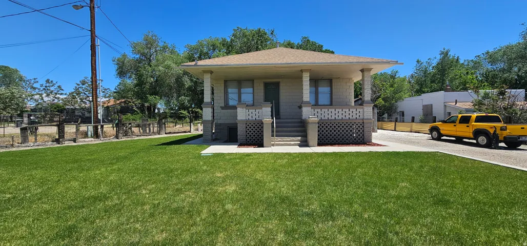 Ranch-style residence featuring a prominent covered front porch with decorative lattice accents