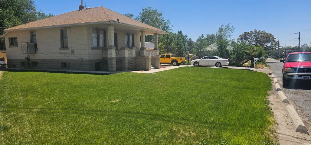 Spacious front yard with a large green lawn