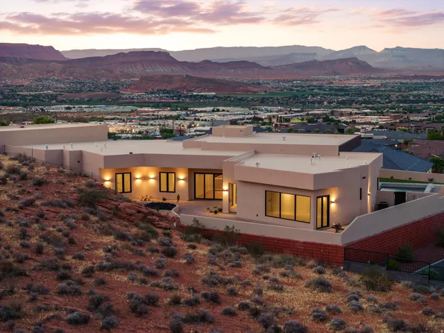 Contemporary stucco exterior featuring a flat roofline and integrated outdoor lighting