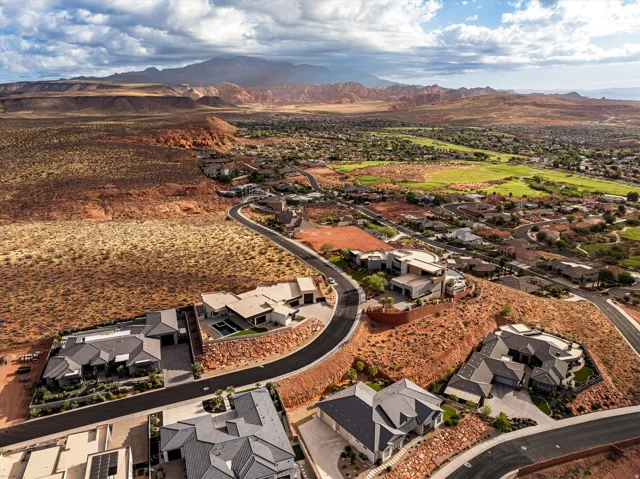Aerial perspective showcasing a residential area with diverse architectural styles, surrounded by desert landscaping and distant mountains