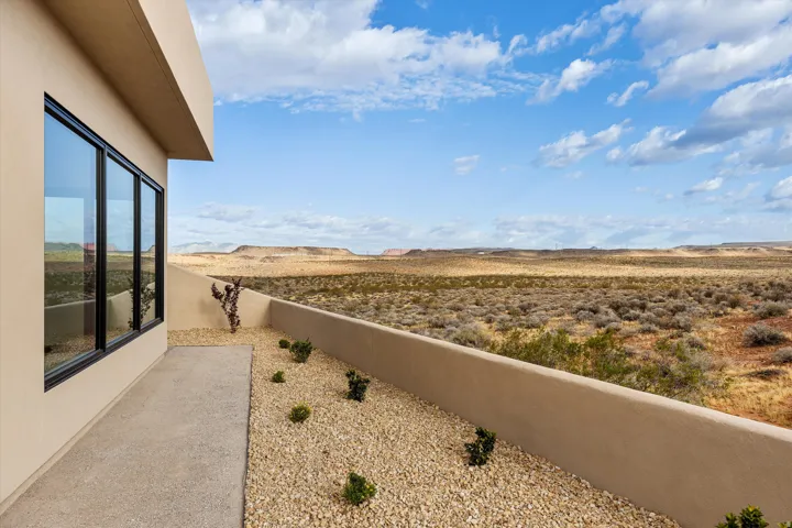 Contemporary exterior with large black-framed windows, a private patio, and a xeriscaped planting area