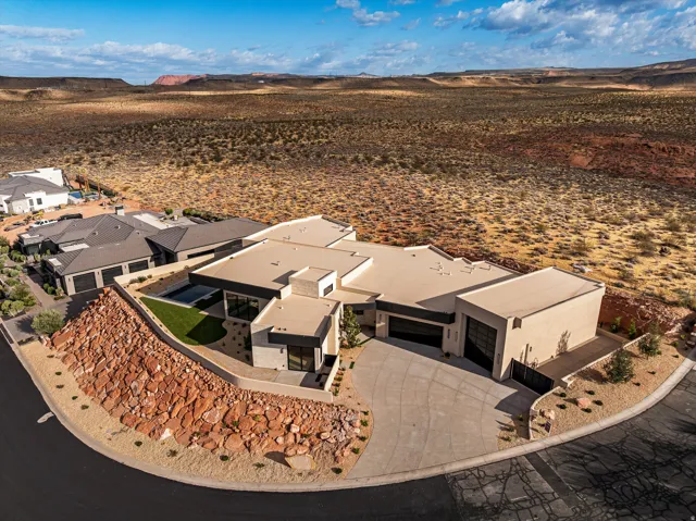 Modern desert architectural residence with a flat roofline, integrated garage, and a courtyard featuring a pool
