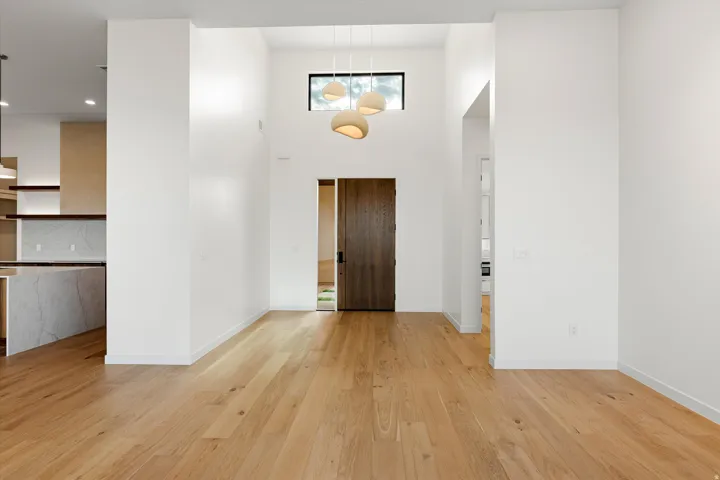 Entryway featuring a double-height ceiling, wood-finish flooring, and a modern chandelier