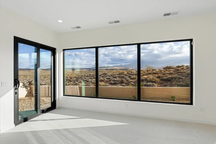 Room featuring a full wall of floor-to-ceiling windows and a sliding glass door with black frames