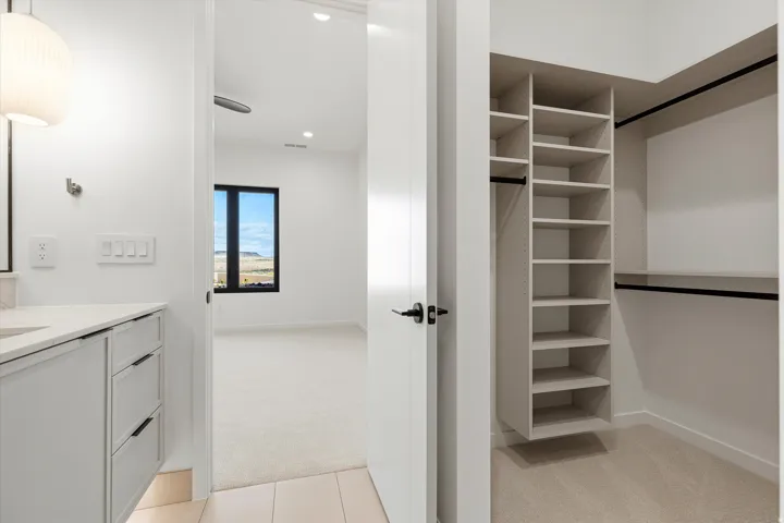 Walk-in closet featuring built-in shelving and hanging rods