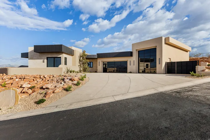 Contemporary desert-style residence featuring a stucco exterior with flat rooflines and black accents