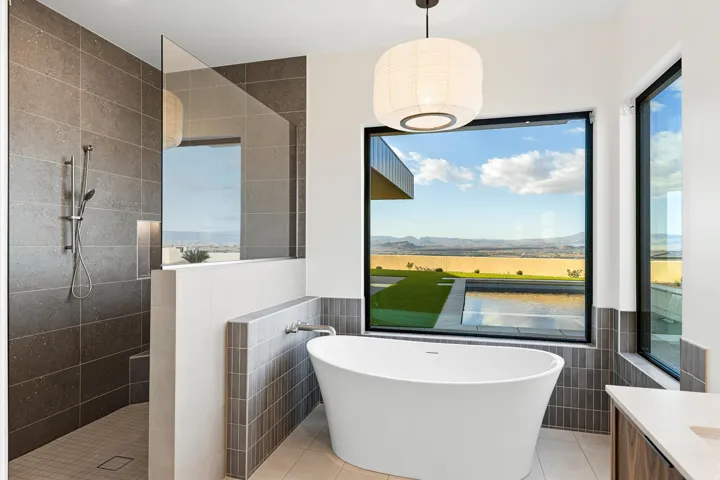 Soaking tub with a large picture window, offering expansive landscape scenery