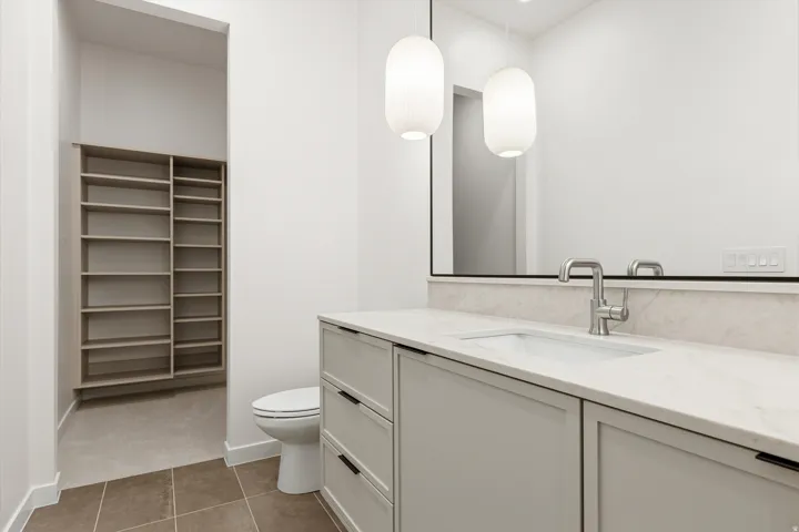 Contemporary bathroom vanity with integrated sink, brushed nickel faucet, and natural stone countertop