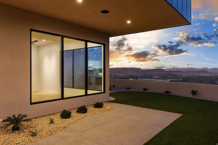 Patio with concrete slab, gravel landscaping, and a grass area