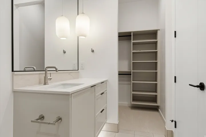 Modern vanity with an integrated sink, quartz countertop, and a tiled backsplash