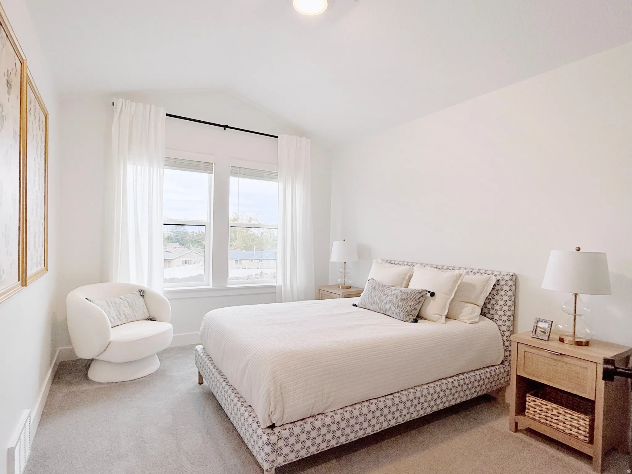 Light-filled room featuring a vaulted ceiling and dual pane windows with white trim