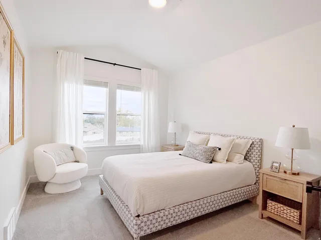 Light-filled room featuring a vaulted ceiling and dual pane windows with white trim