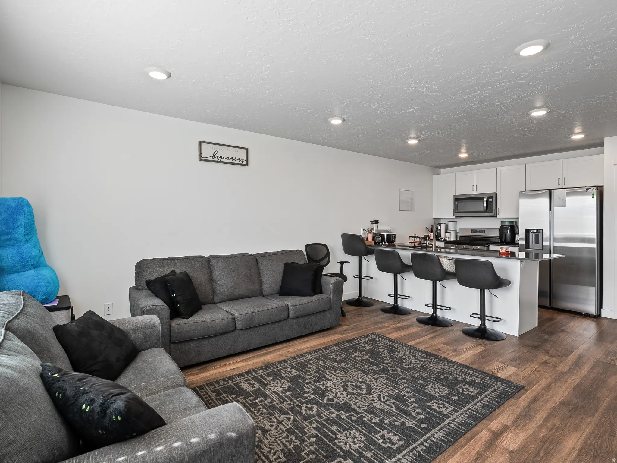 Open-concept living area featuring wood-finish flooring and recessed lighting
