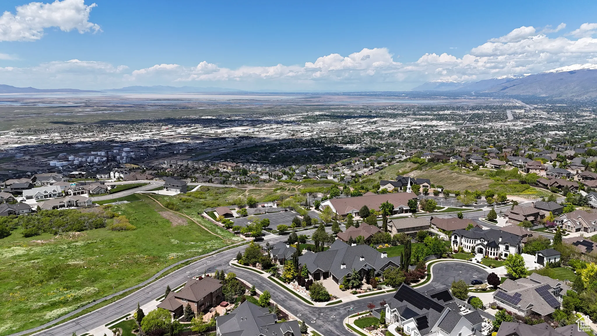 Expansive aerial showcasing a residential area with varied architectural styles under a bright blue sky