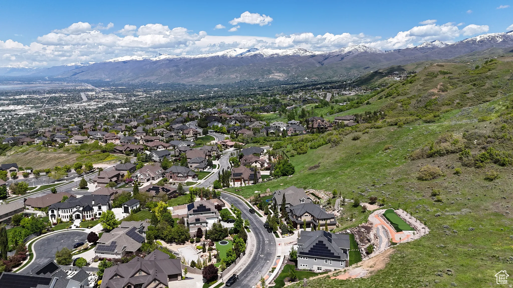 Expansive residential area with diverse home styles, set against a backdrop of distant snow-capped mountains