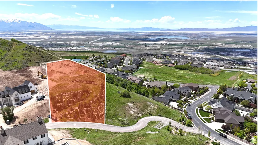 Expansive property outlined in red, featuring a mountainous backdrop and distant urban landscape