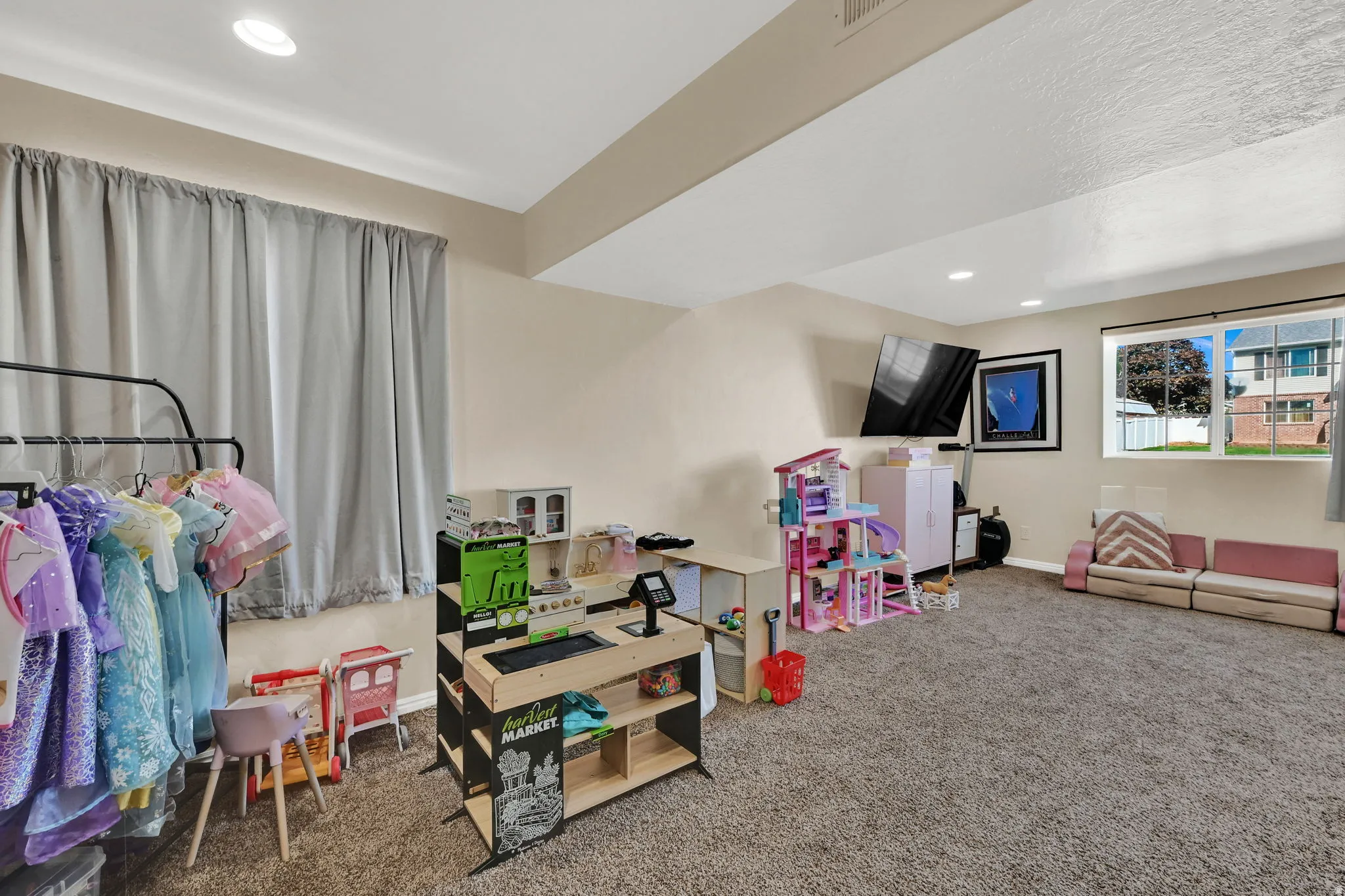 Spacious room featuring neutral carpeting, recessed lighting, and ample natural light from multiple windows