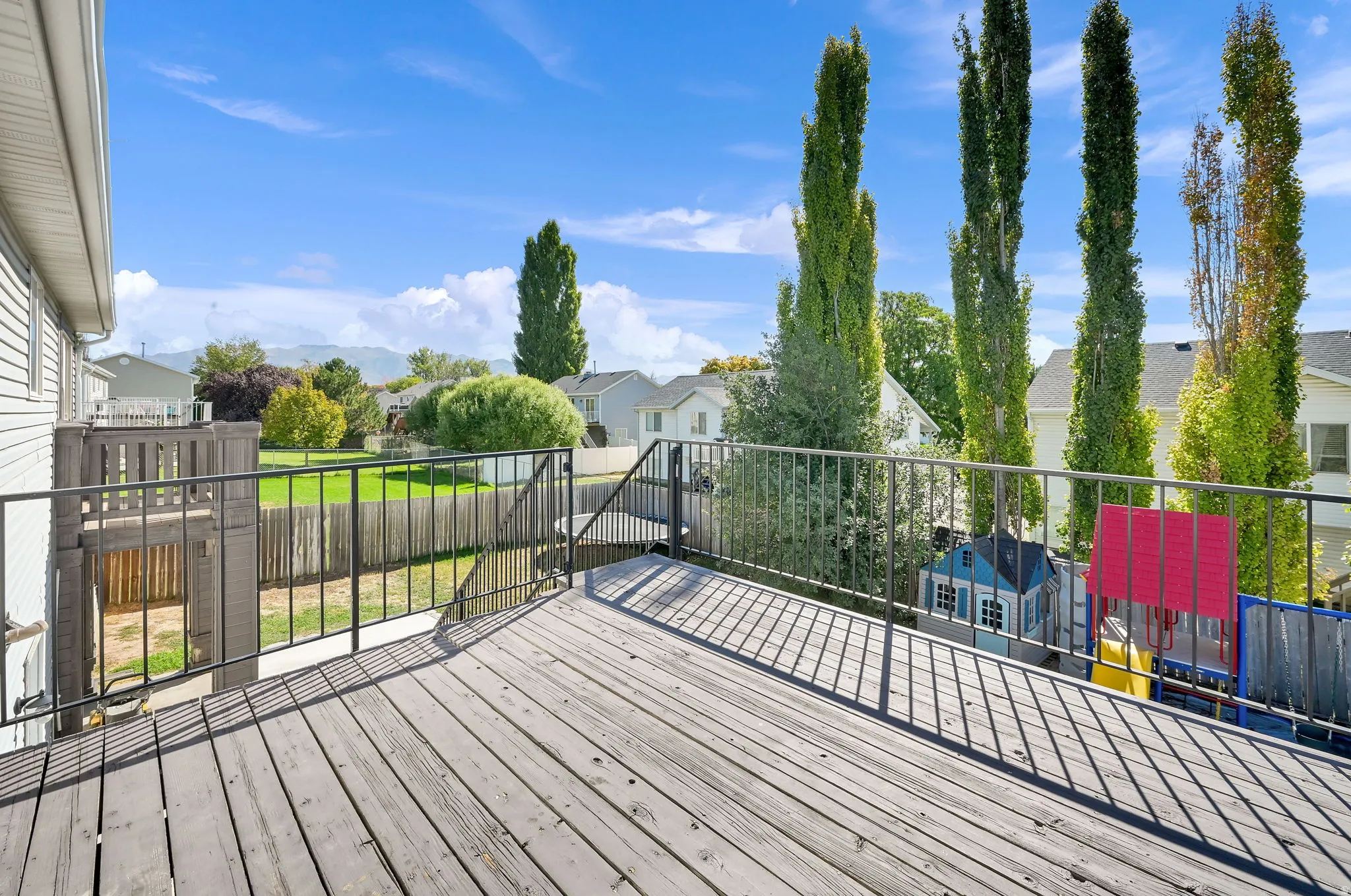 Spacious wood-plank deck with black metal railings