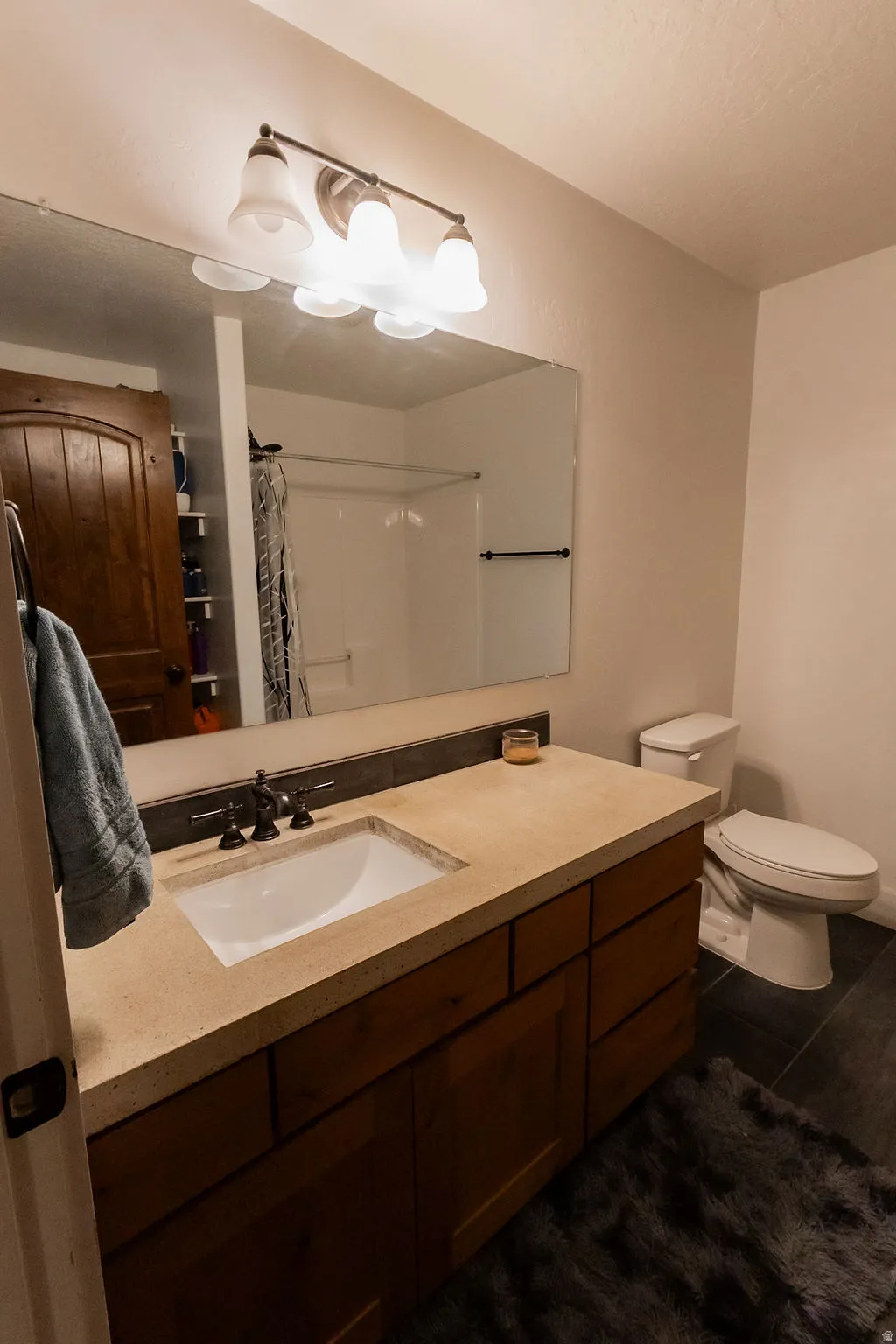 Spacious bathroom featuring a large vanity with integrated sink, dark wood cabinetry, and a light-toned countertop