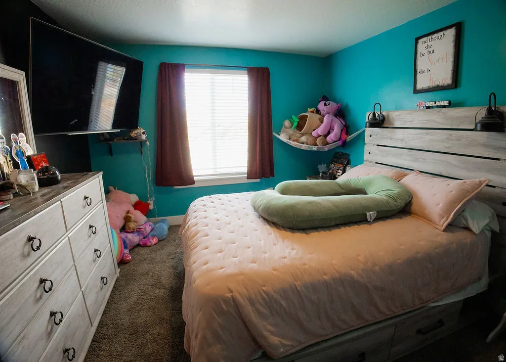 Window with blinds and drapes, wood-finish headboard, and wood-finish dresser with ring pull hardware