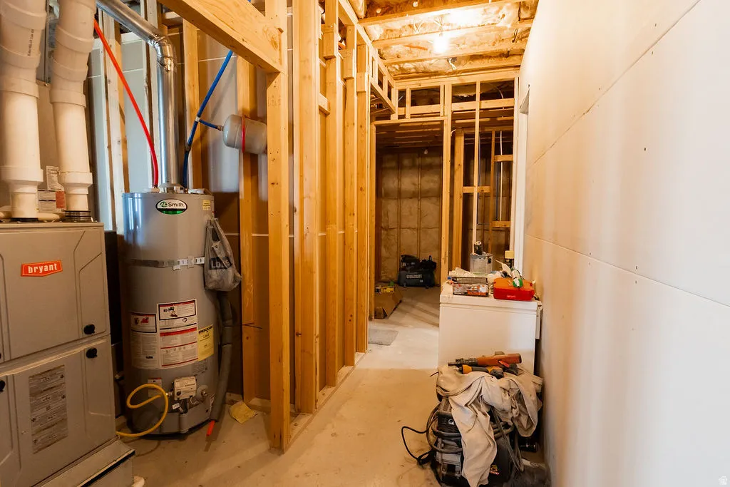 Unfinished basement space featuring visible wood framing, HVAC system, and water heater