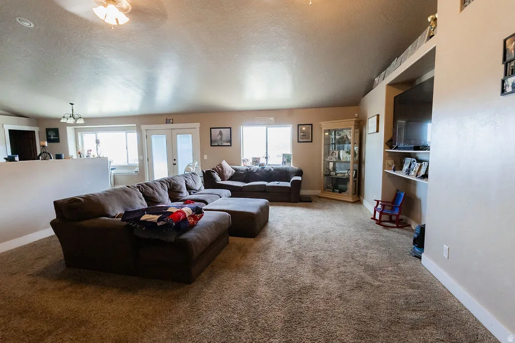 Spacious living area featuring carpeted flooring and light-toned walls