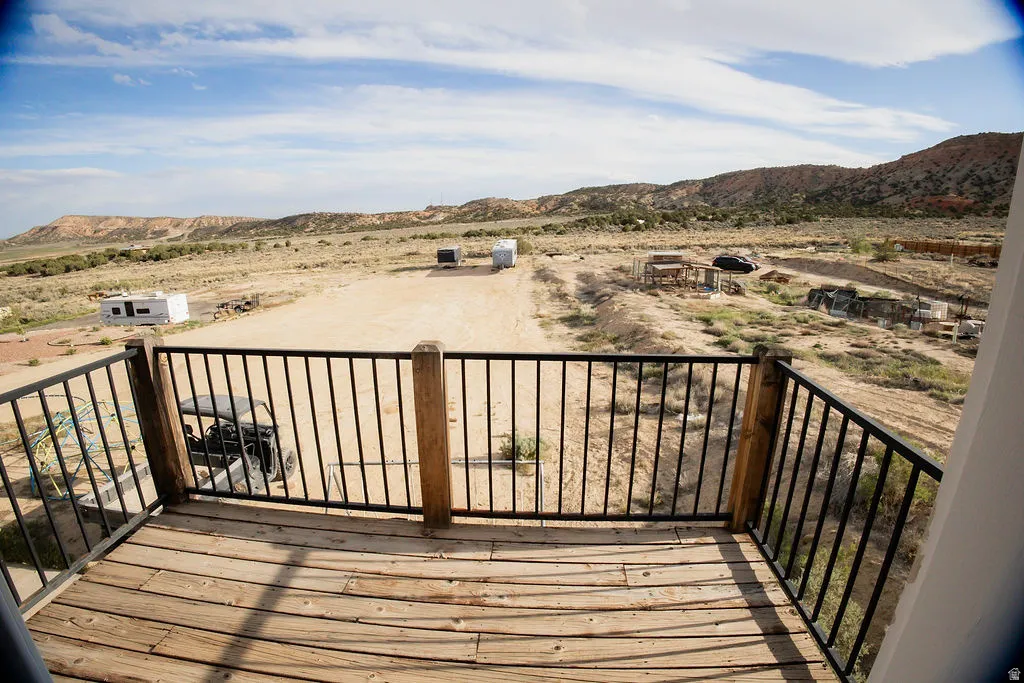 Wood-finish deck with a black metal railing and wooden posts