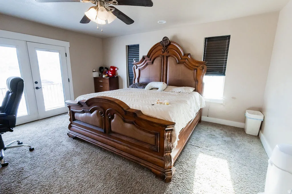 Carpeted room with a ceiling fan, light-toned walls, and a window with dark blinds