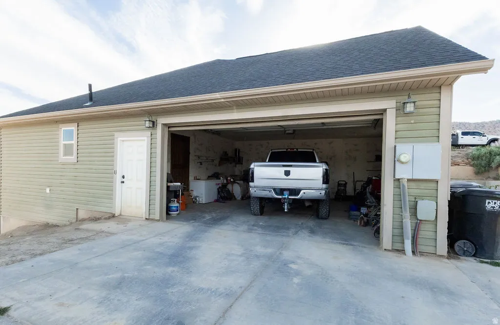 Attached two-car garage with concrete driveway and light green siding