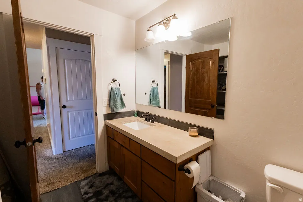 Bathroom vanity featuring a light-toned countertop, integrated rectangular sink, and wood-finish cabinetry
